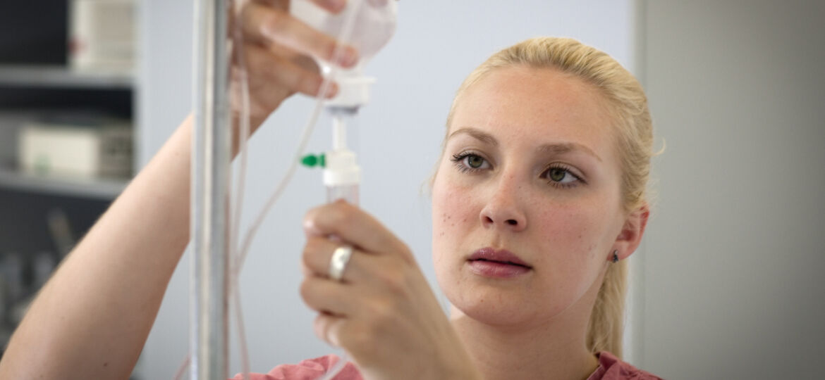 female blond nurse is preparing an infusion